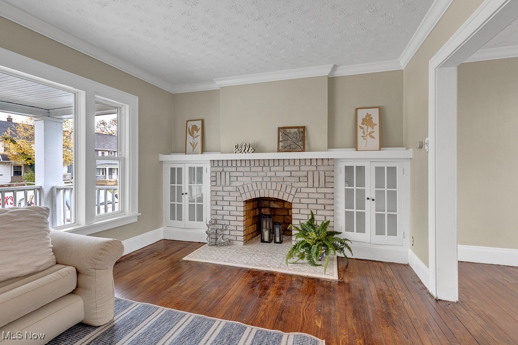2127 Rossmoor Road Cleveland Heights, OH 44118 - Photo 5 of 21 Living area with baseboards, crown molding, a textured ceiling, and hardwood / wood-style floors