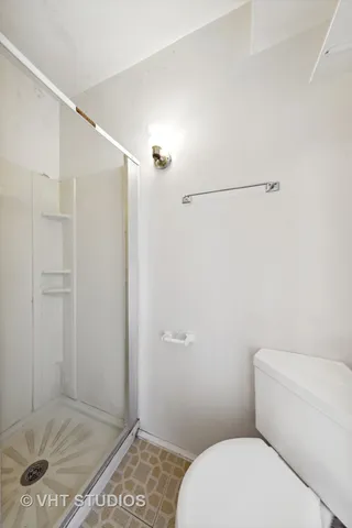 a bathroom with a toilet and a shower