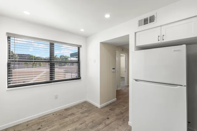 a view of a big room with wooden floor and windows