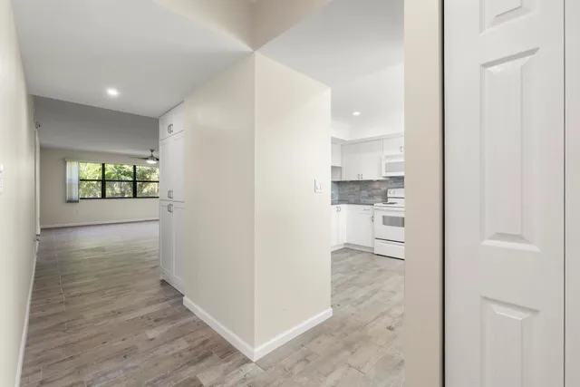 a view of empty room with wooden floor and fan