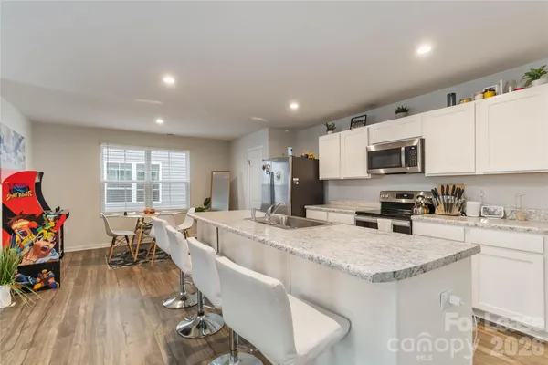 a large kitchen with granite countertop lots of counter top space and furniture