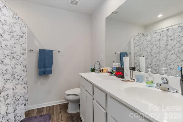 a bathroom with a sink vanity mirror and toilet
