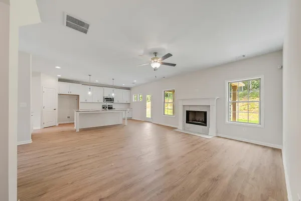 a view of an empty room with a window and fireplace