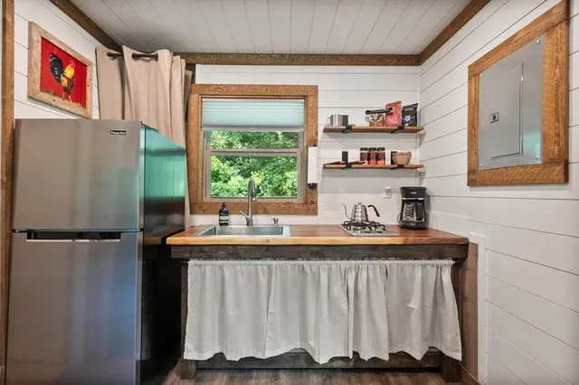 a kitchen with stainless steel appliances granite countertop a table chairs and a refrigerator