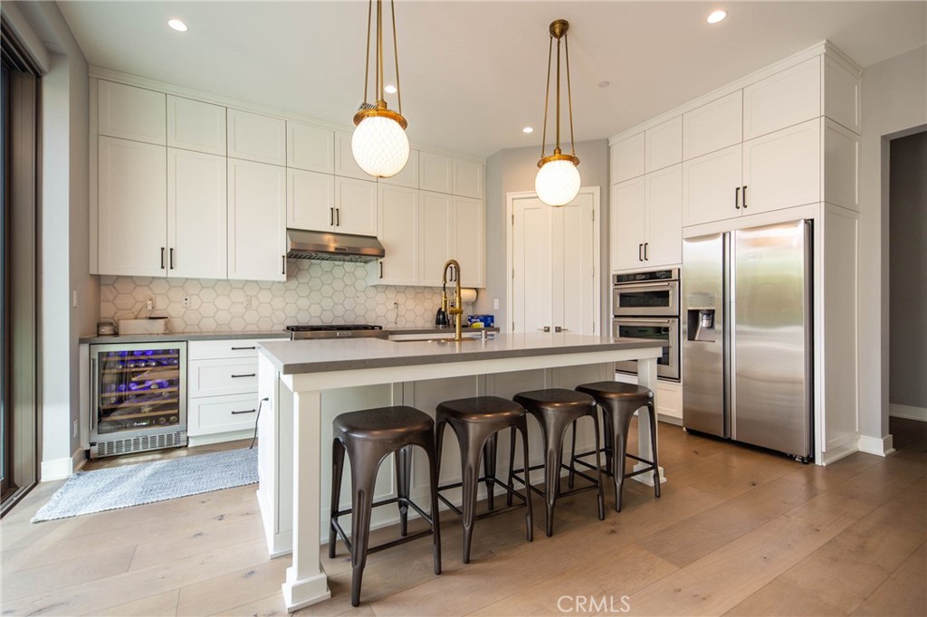 119 Wheatgrass Irvine, CA 92618 - Photo 8 of 32 a kitchen with stainless steel appliances granite countertop a sink a stove a refrigerator and island with wooden floor