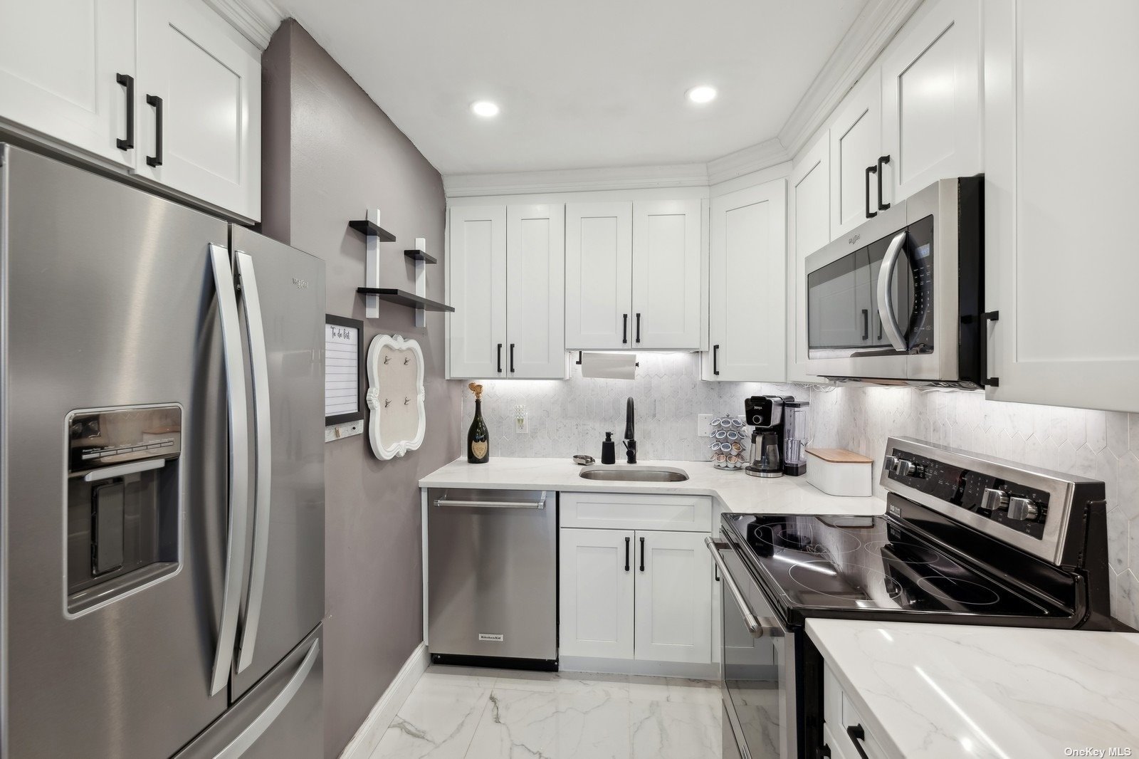 a kitchen with stainless steel appliances a sink stove refrigerator and cabinets