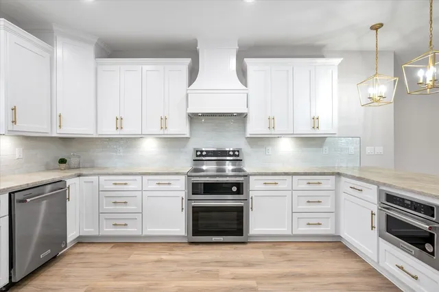 a kitchen with white cabinets and sink