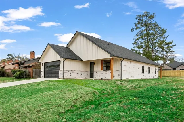 a view of a house with a yard and sitting area
