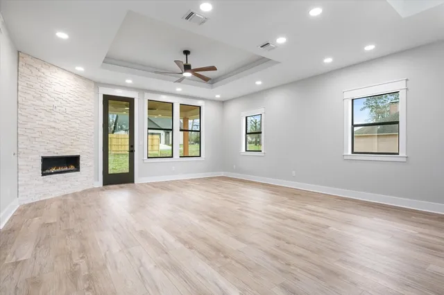a view of an empty room with a window and kitchen view