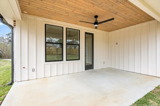 a view of a yard in front of a house with large trees
