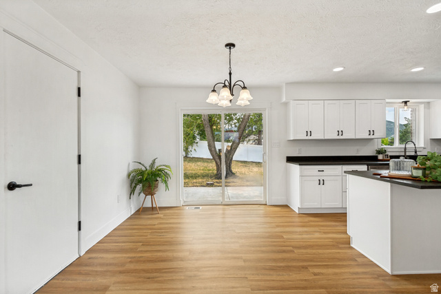 62 South Clark Lane Elk Ridge, UT 84651 - Photo 7 of 30 Open concept living/dining area with wood-finish flooring, white cabinetry, and dark countertops