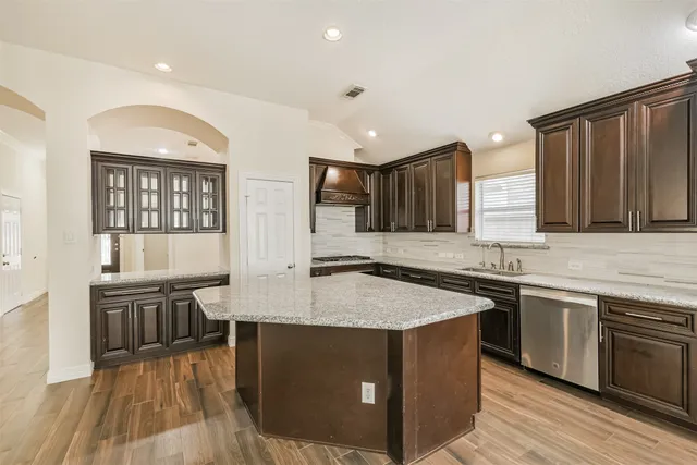 a view of a big room with wooden floor and a kitchen