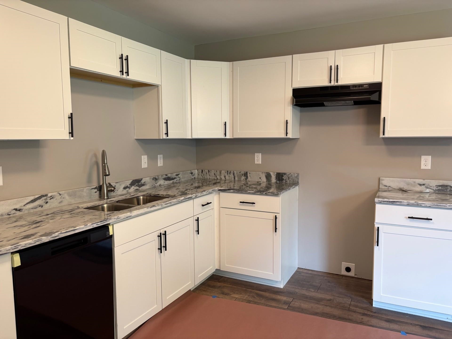3701 Whittier Road Memphis, TN 38108 - Photo 13 of 13 Kitchen featuring dishwasher, under cabinet range hood, dark wood-type flooring, and white cabinets