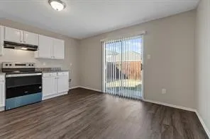 a view of a kitchen with wooden floor electronic appliances and windows