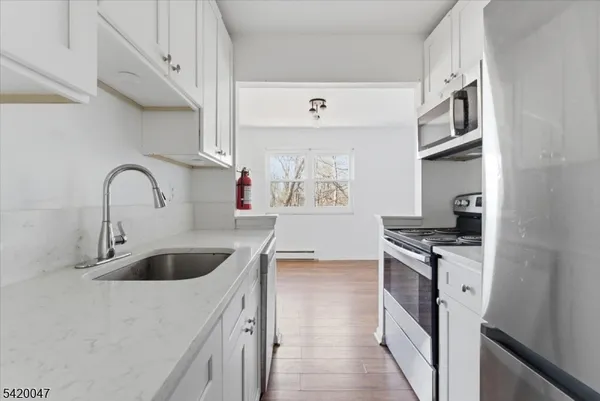 a kitchen with stainless steel appliances granite countertop a sink and a stove
