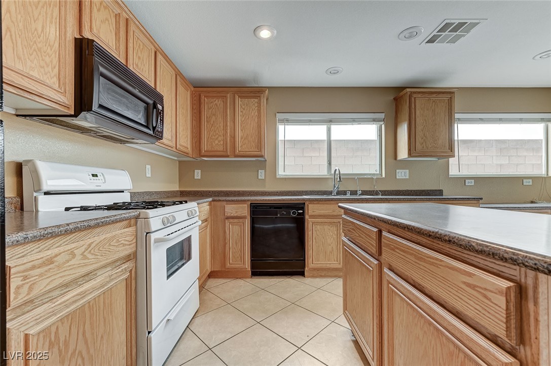 83 Lockheed Avenue Las Vegas, NV 89183 - Photo 10 of 28 Kitchen featuring black appliances, light tile patterned floors, recessed lighting, dark countertops, and light brown cabinets