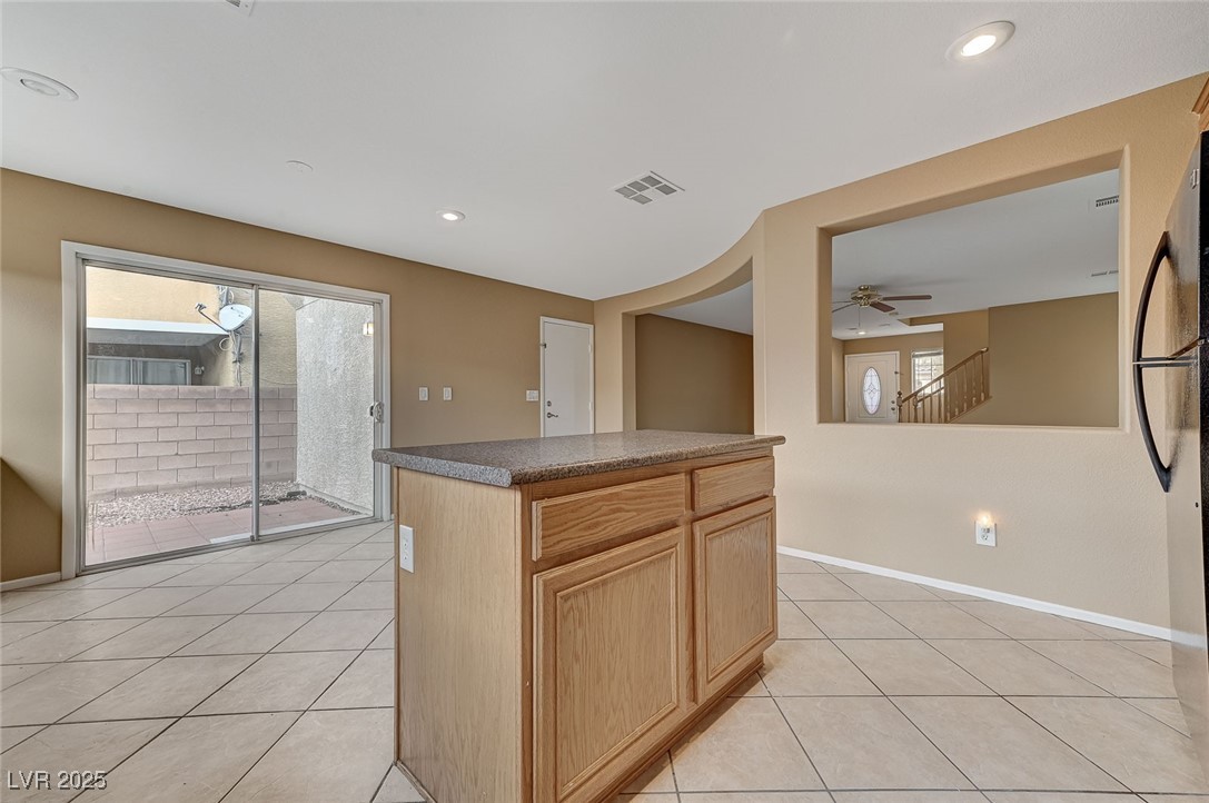 83 Lockheed Avenue Las Vegas, NV 89183 - Photo 11 of 28 Kitchen featuring light tile patterned flooring, light brown cabinetry, a center island, recessed lighting, and a ceiling fan