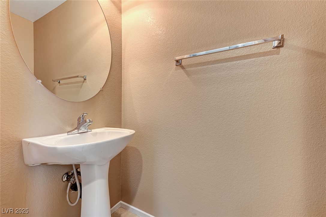 83 Lockheed Avenue Las Vegas, NV 89183 - Photo 13 of 28 Bathroom with a textured wall and a sink
