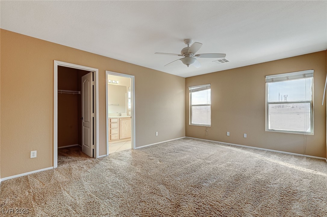 83 Lockheed Avenue Las Vegas, NV 89183 - Photo 15 of 28 Unfurnished bedroom with carpet flooring, a walk in closet, and ceiling fan