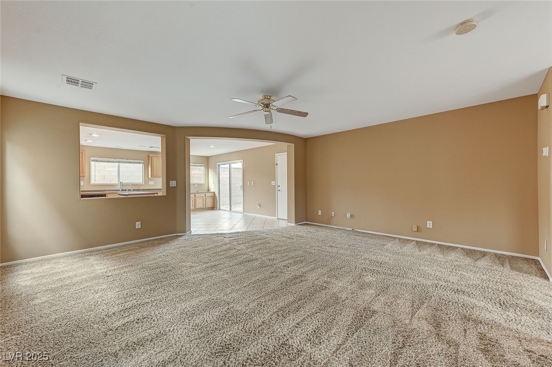 83 Lockheed Avenue Las Vegas, NV 89183 - Photo 3 of 28 Unfurnished room featuring light colored carpet and a ceiling fan