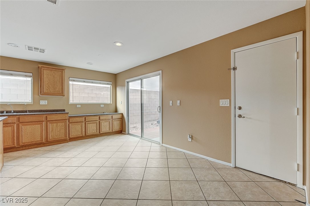 83 Lockheed Avenue Las Vegas, NV 89183 - Photo 6 of 28 Kitchen with light tile patterned floors, brown cabinetry, and recessed lighting