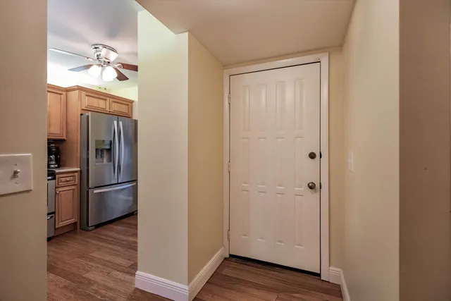 a kitchen with a refrigerator and wooden floor