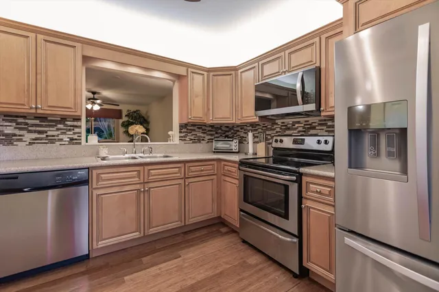 a kitchen with stainless steel appliances a stove microwave and sink