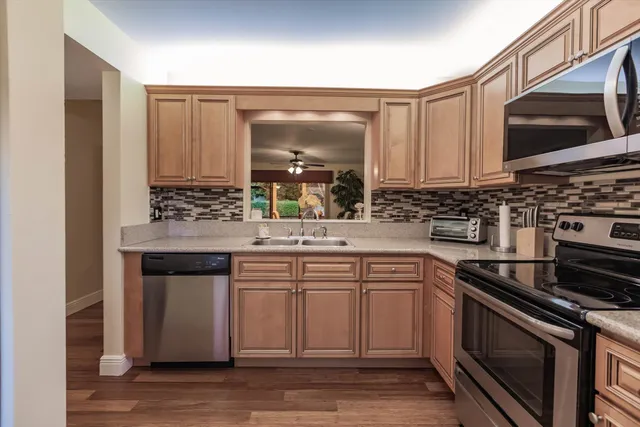 a kitchen with stainless steel appliances a stove microwave and sink