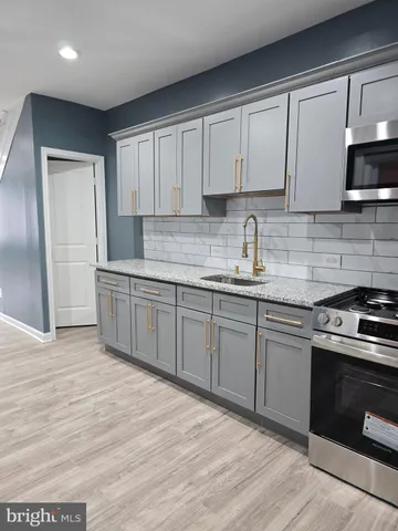 a kitchen with stainless steel appliances granite countertop a sink a stove and a microwave