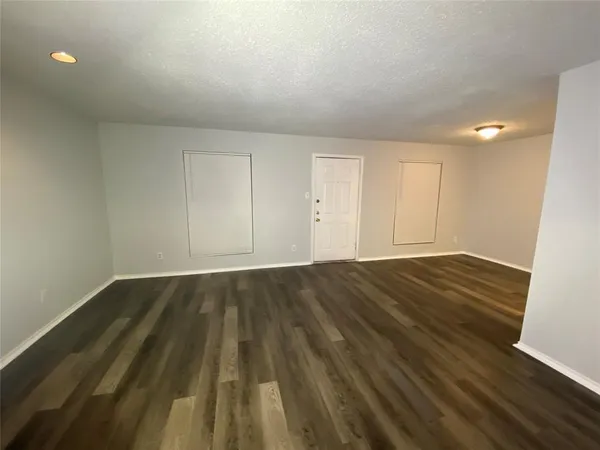 a view of an empty room and wooden floor