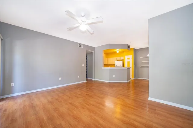 a view of an empty room with glass door and wooden floor