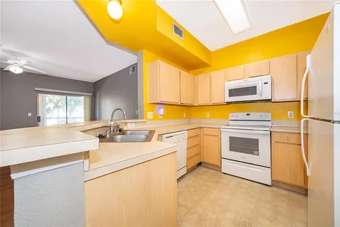 a kitchen with a refrigerator and a stove top oven