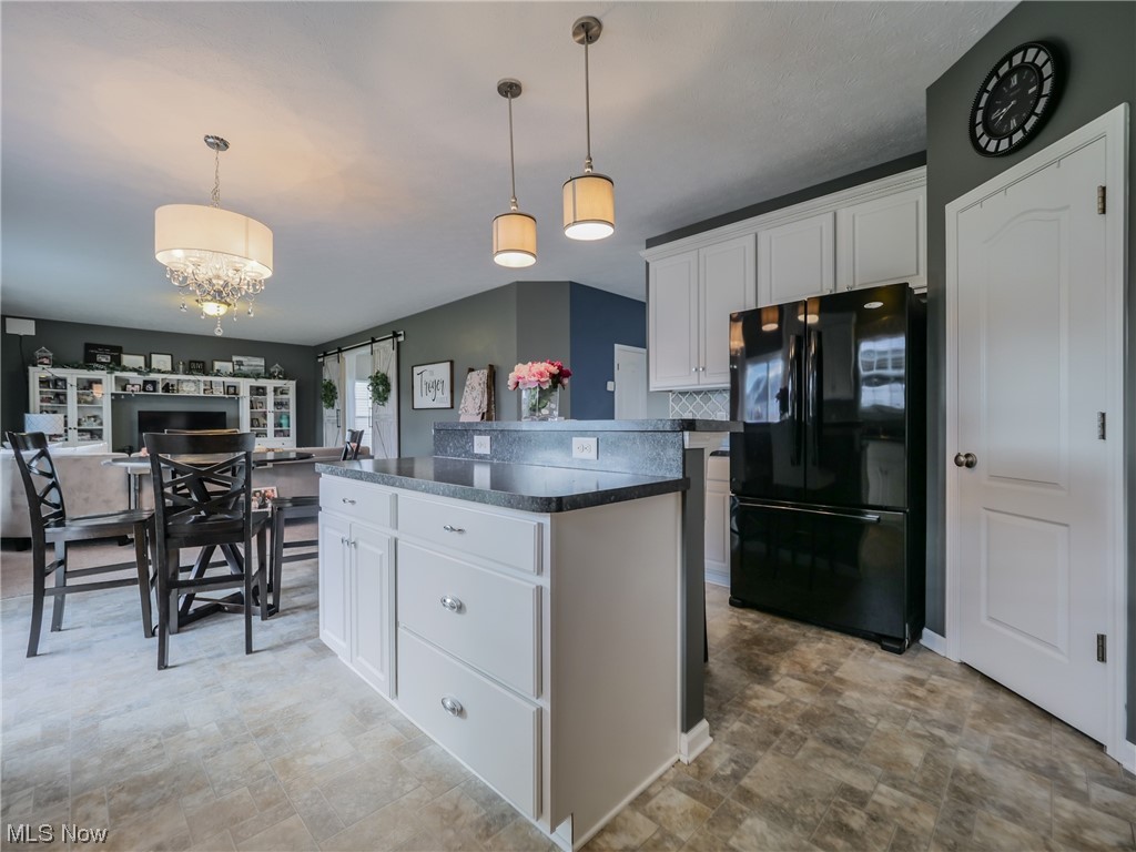 37571 Amber Way North Ridgeville, OH 44039 - Photo 8 of 35 Kitchen with a kitchen island, white cabinetry, black fridge, and pendant lighting