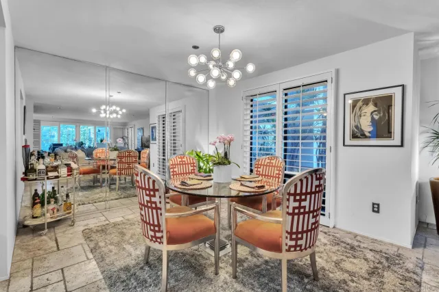 a outdoor dining space with furniture a chandelier and window