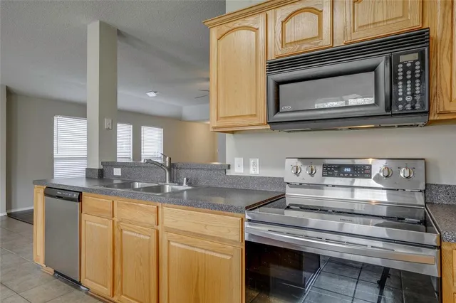a kitchen with stainless steel appliances granite countertop a stove microwave and cabinets