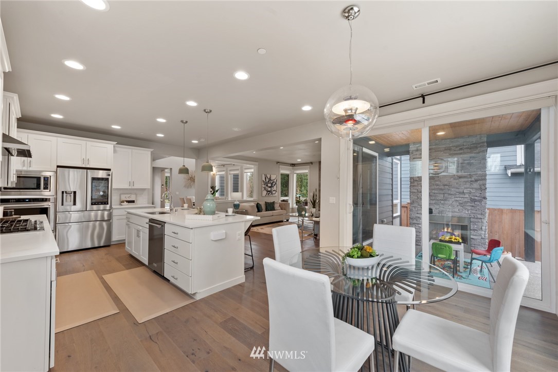 23417 26th Avenue Southeast Bothell, WA 98021 - Photo 15 of 40 a kitchen with a dining table chairs stainless steel appliances and cabinets