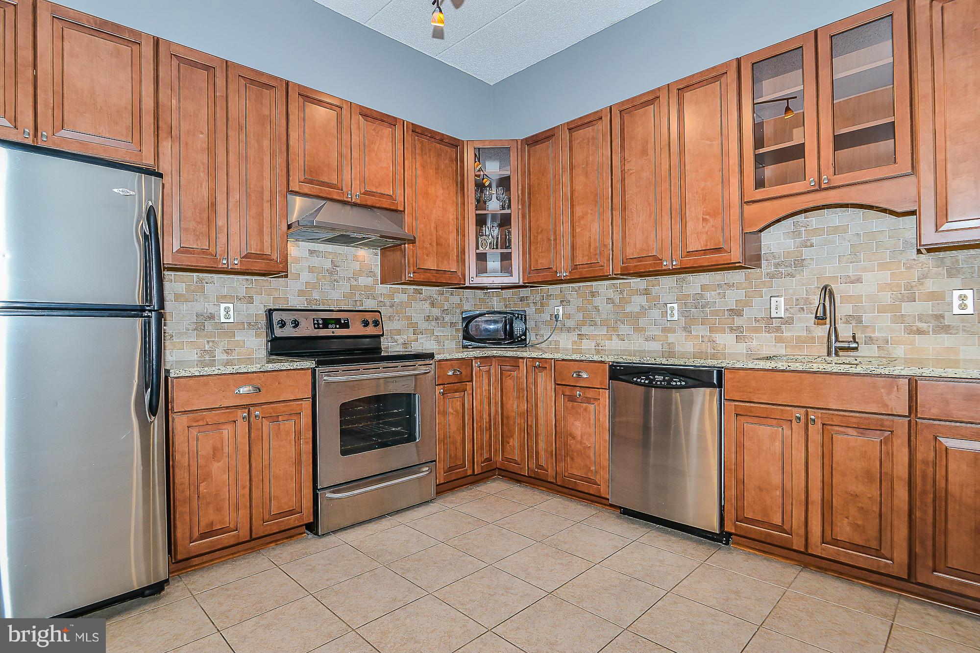 11620 Ivystone Court, Unit 101 Reston, VA 20191 - Photo 1 of 20 a kitchen with stainless steel appliances granite countertop a refrigerator sink and cabinets