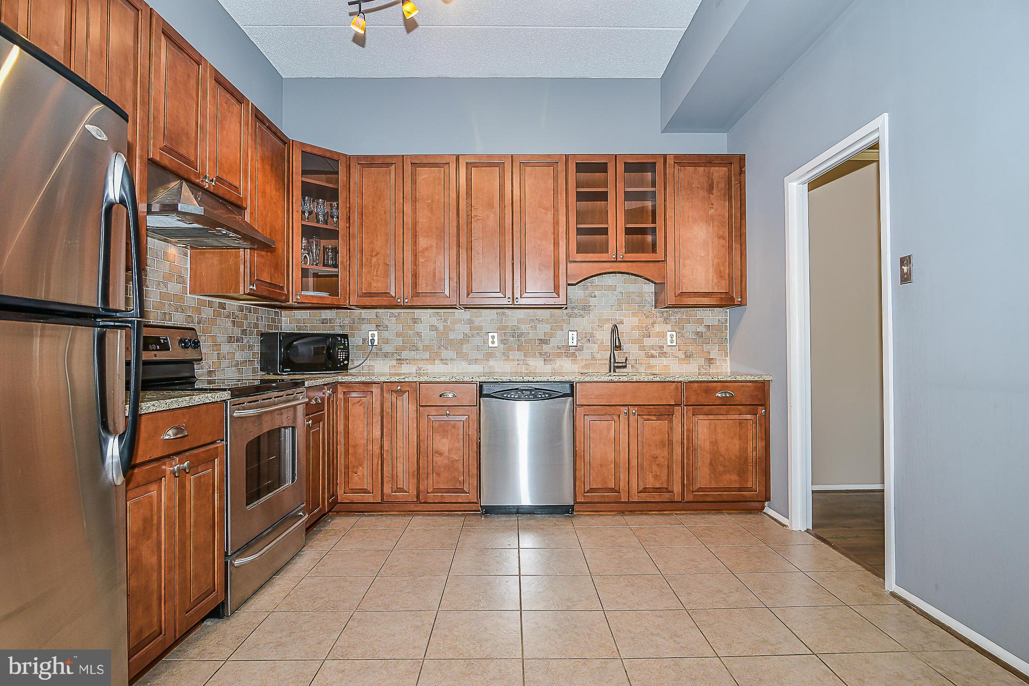 11620 Ivystone Court, Unit 101 Reston, VA 20191 - Photo 14 of 20 a kitchen with stainless steel appliances granite countertop a stove a sink and a refrigerator