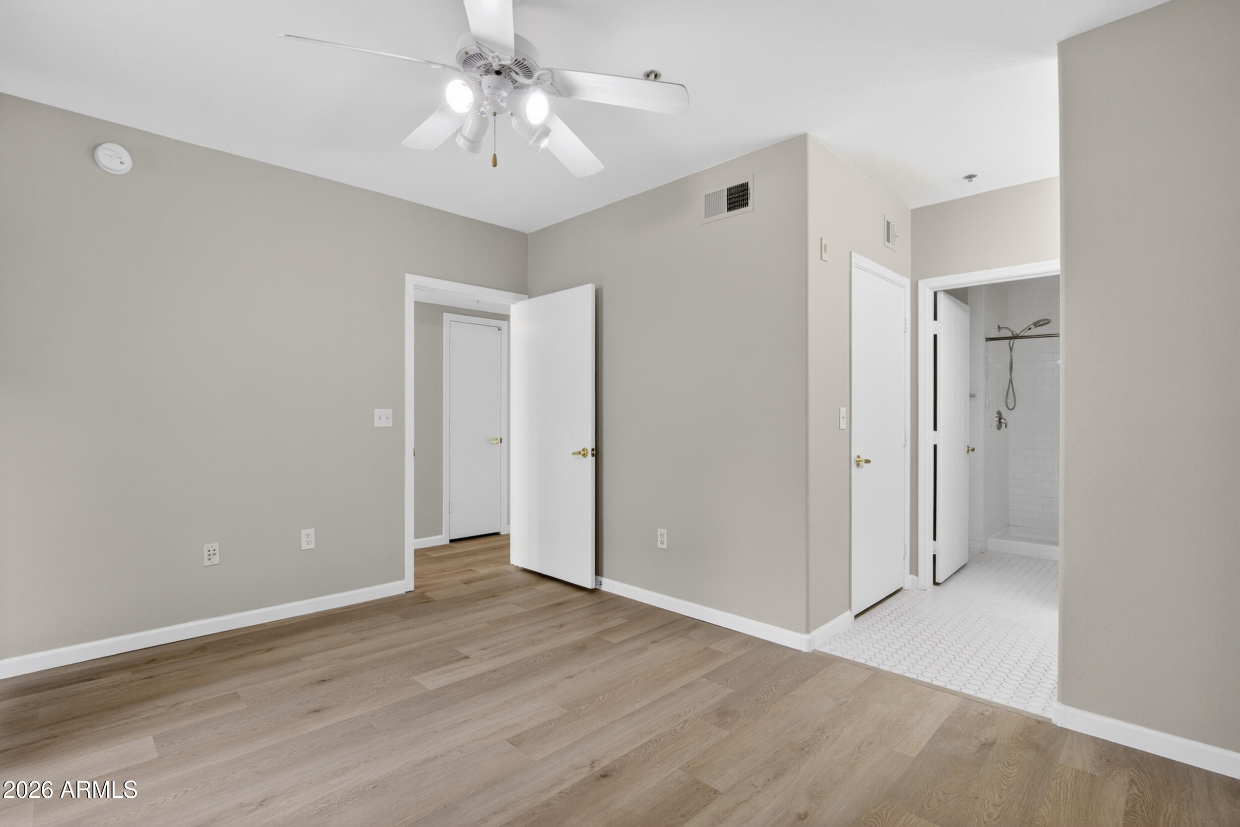 2134 East Broadway Road, Unit 1042 Tempe, AZ 85282 - Photo 26 of 33 an empty room with wooden floor and ceiling fan
