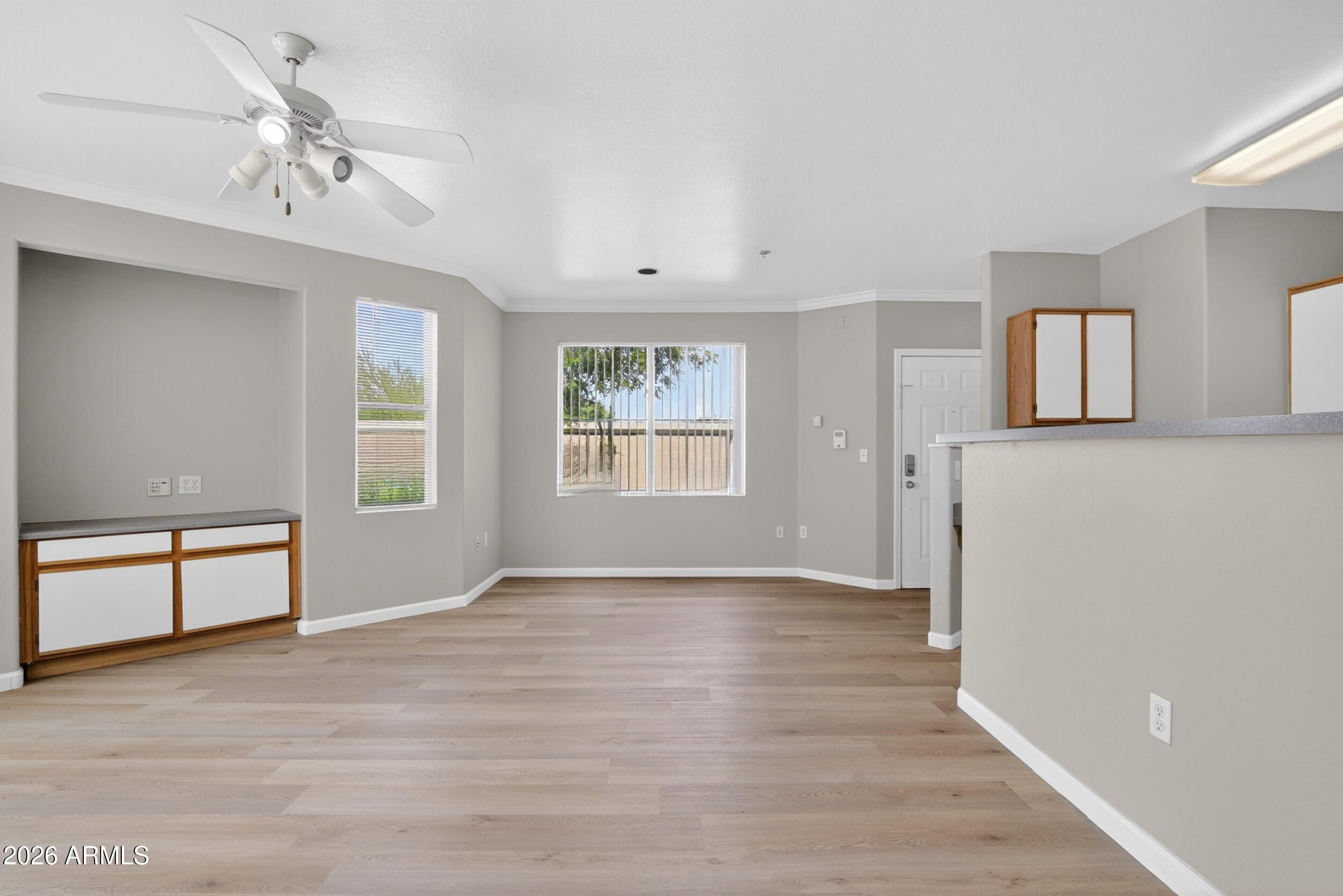 2134 East Broadway Road, Unit 1042 Tempe, AZ 85282 - Photo 4 of 33 an empty room with windows and ceiling fan