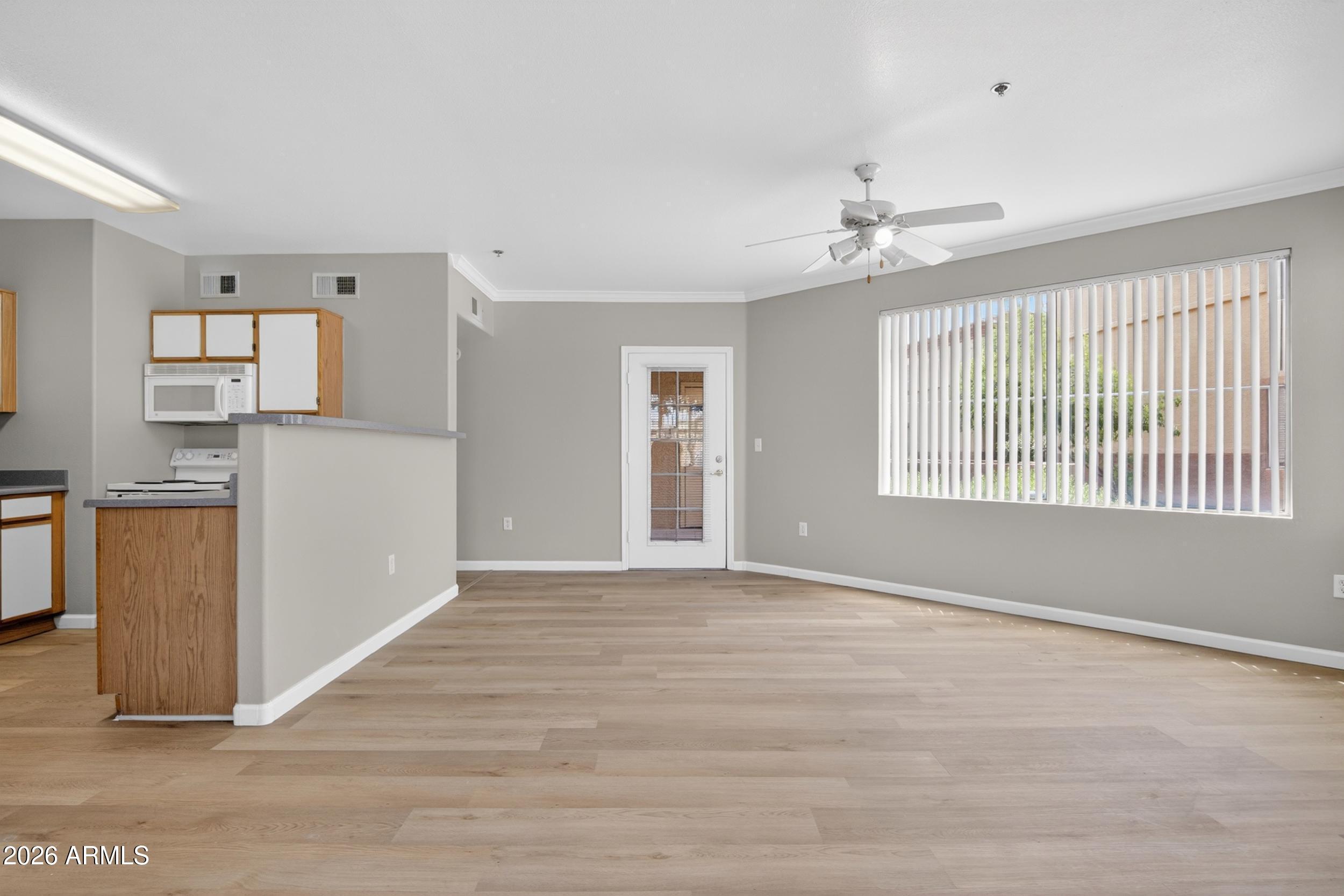 2134 East Broadway Road, Unit 1042 Tempe, AZ 85282 - Photo 6 of 33 a view of an empty room with window and wooden floor