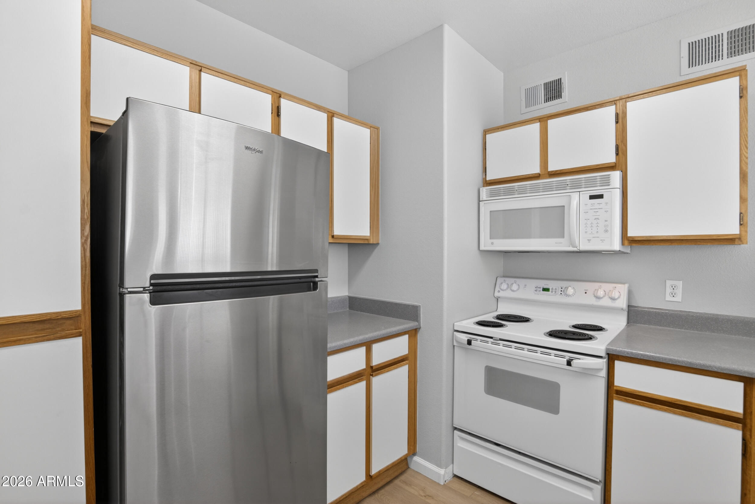 2134 East Broadway Road, Unit 1042 Tempe, AZ 85282 - Photo 9 of 33 a white refrigerator freezer and a stove sitting inside of a kitchen