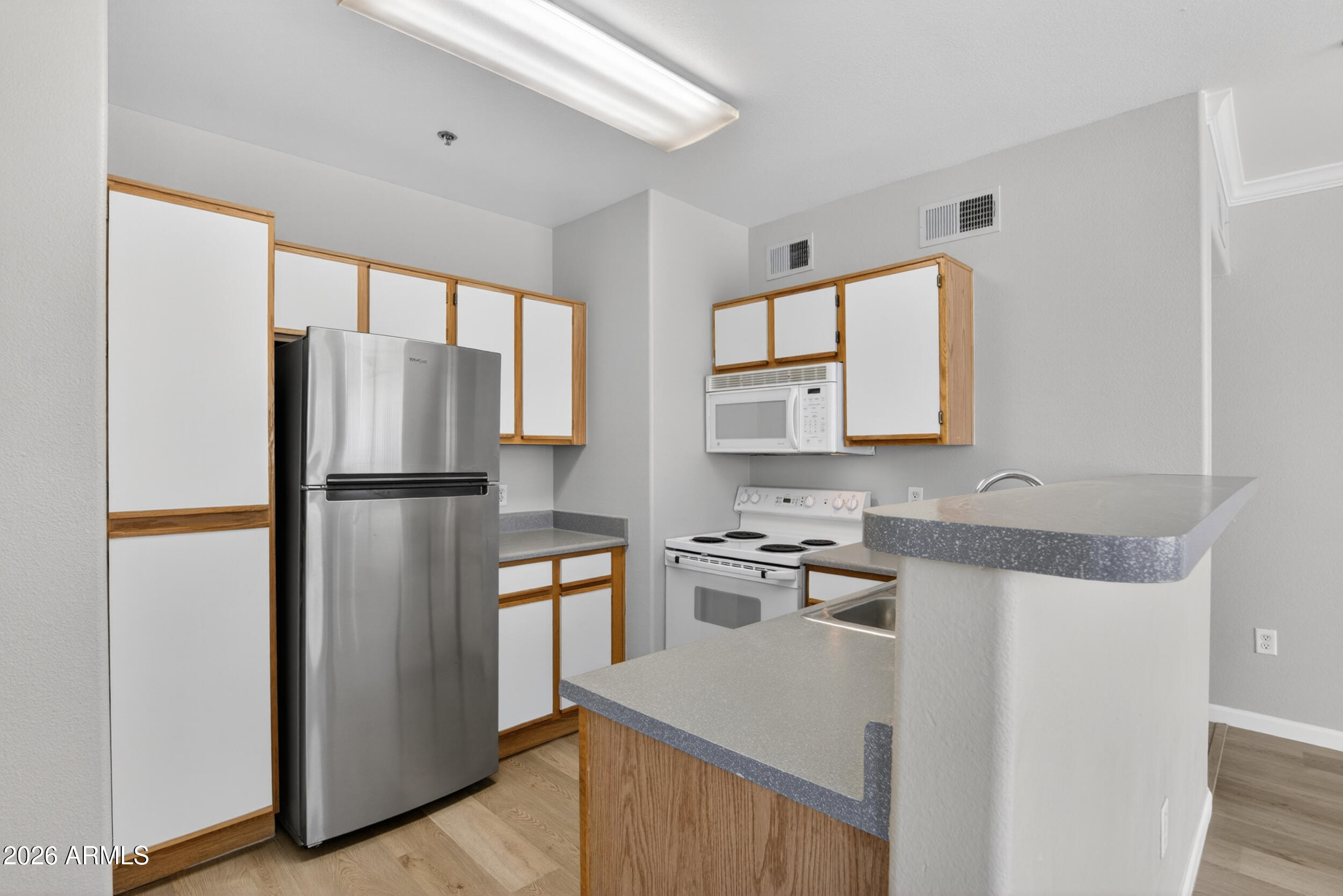 2134 East Broadway Road, Unit 1042 Tempe, AZ 85282 - Photo 10 of 33 a kitchen with granite countertop a refrigerator and a sink