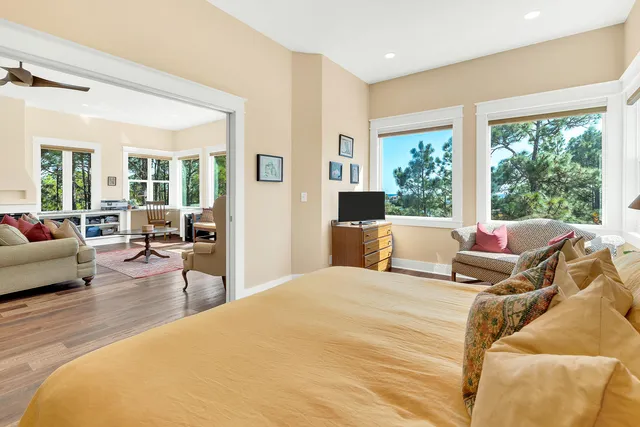 a living room with furniture a flat screen tv and a floor to ceiling window