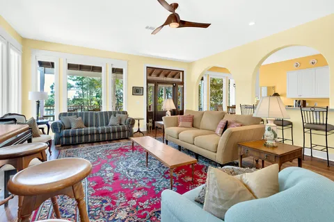 a kitchen with stainless steel appliances a stove a sink a oven a dining table and chairs with wooden floor