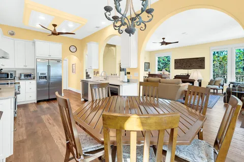 a kitchen with stainless steel appliances granite countertop a table chairs sink and cabinets