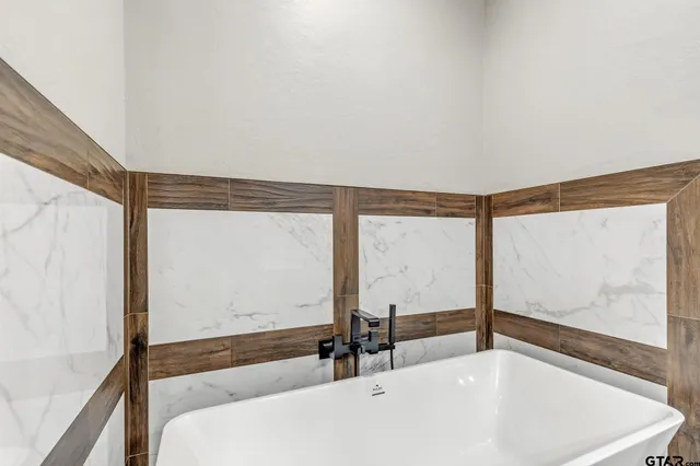 a bathroom with a bathtub and mirror