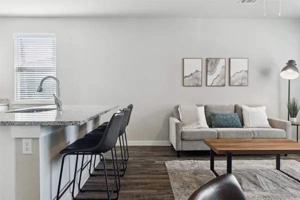 a kitchen with granite countertop a dining table chairs and a potted plant
