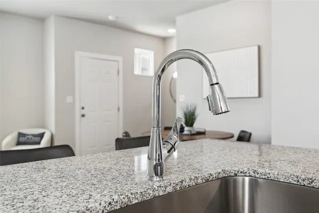 a kitchen with granite countertop white cabinets and stainless steel appliances
