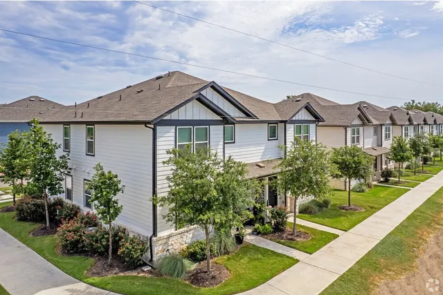 a front view of a house with a garden and plants
